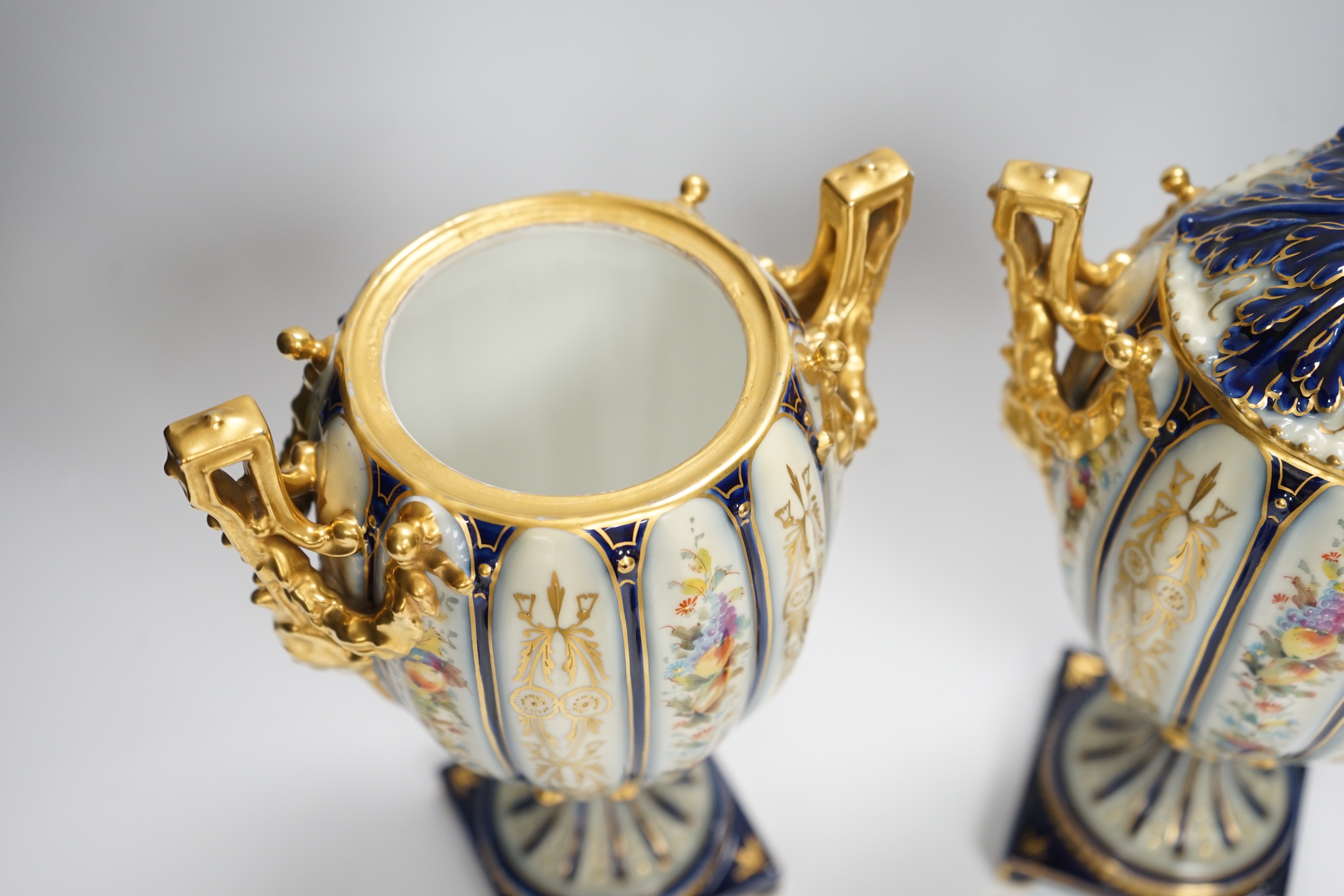 A pair of Rudolstadt gilt decorated urns and covers, 29cm